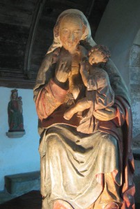 Marienstatue mit Jesuskind auf dem linken Arm, mit der rechten Hand holt die Gottesmutter ihre Brust aus dem Mieder
