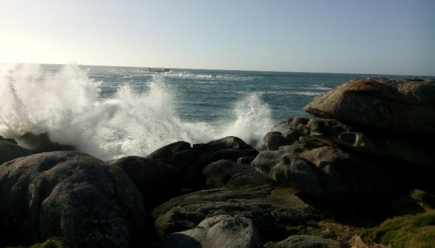 Wellen brechen sich an Felsen bei Kerlouan