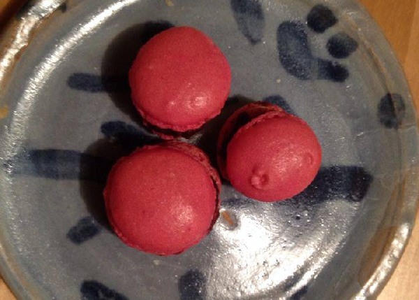 Drei rosa Macarons mit Pistazien-Schokoladen-Ganache